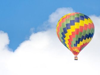 Yellow, blue, green, and red hot air balloon in the sky