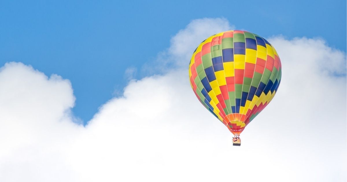 Yellow, blue, green, and red hot air balloon in the sky