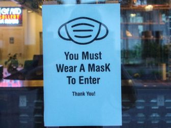 Mask sign in window of storefront.