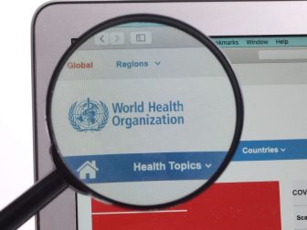 WHO World Health Organization website under magnifying glass