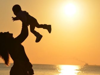 Silhouette of woman and baby on the beach