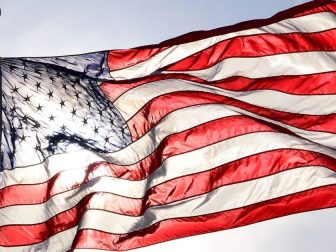 The above stock photo shows an American flag waving in the wind.