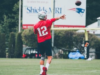 Tom Brady throwing football at Patriots training camp