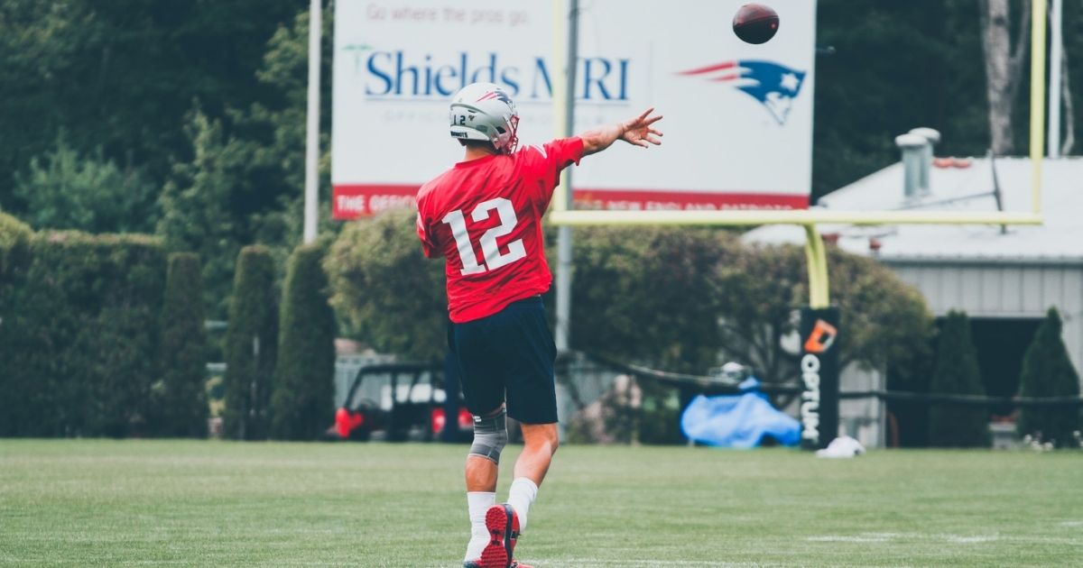 Tom Brady throwing football at Patriots training camp