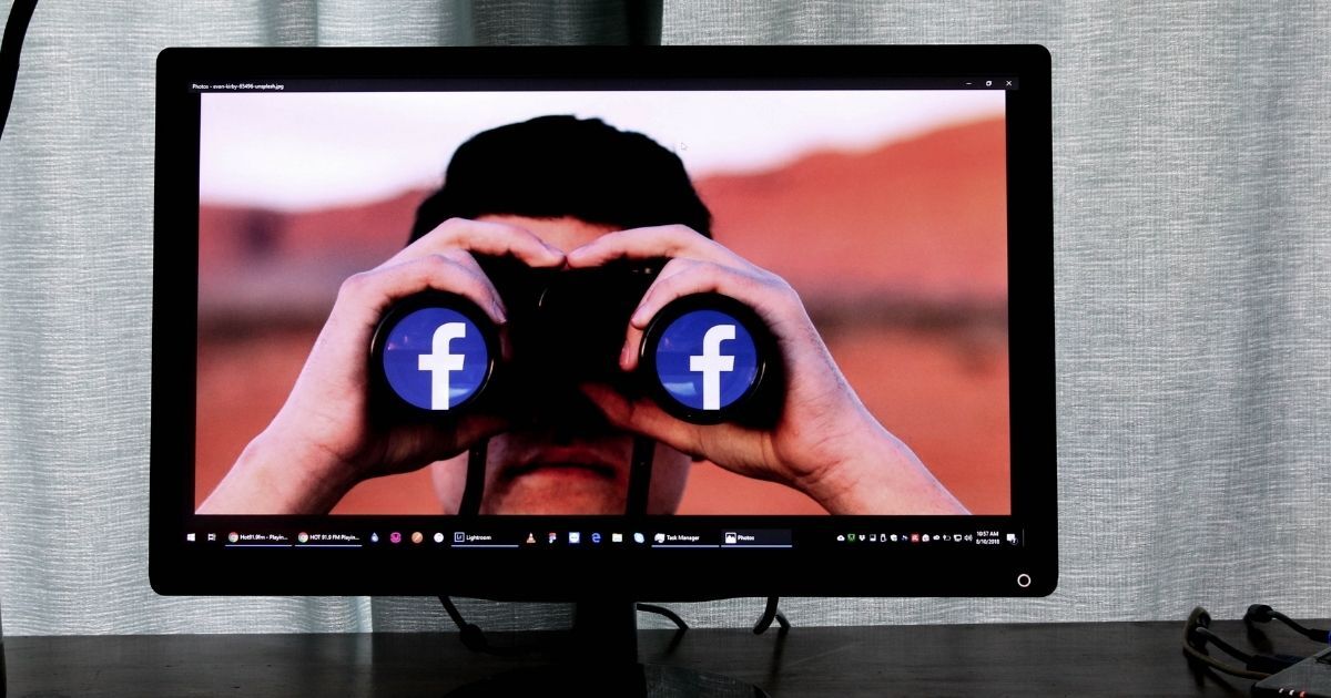 Television showing man looking through binoculars with the Facebook logo in the lens.