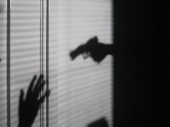 Silhouette of hand holding a gun