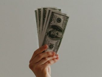 Hand holding 100 dollar bills
