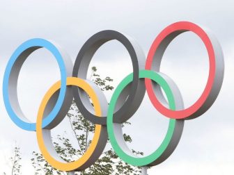 The above photo shows the Olympic rings above the Live Site East in front of the Velodrome.