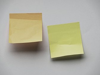 two sticky notes on a blank, white wall