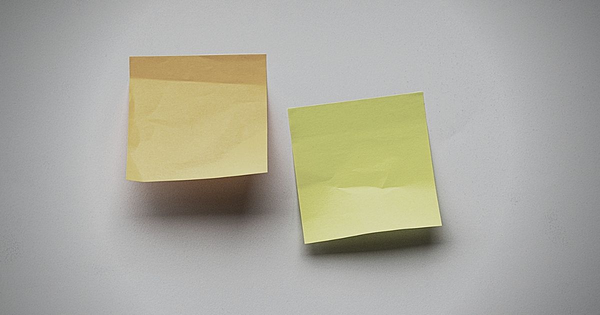 two sticky notes on a blank, white wall