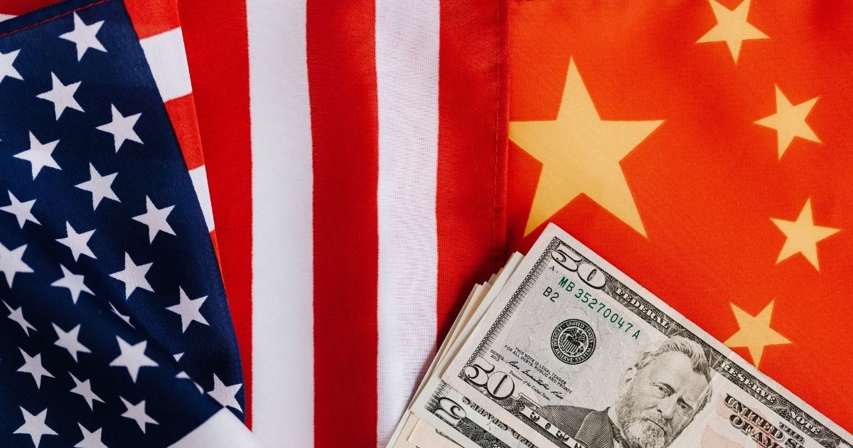 USA and Chinese flag with money on top