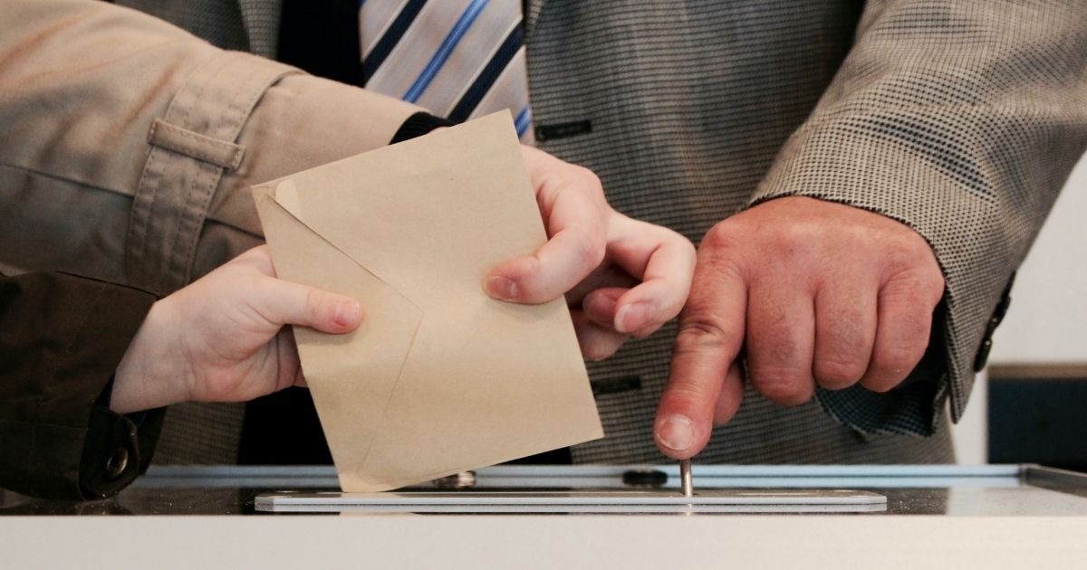 The above stock photo shows someone voting.