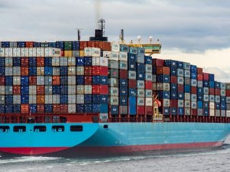 Cargo ship with stacked crates sailing in the water