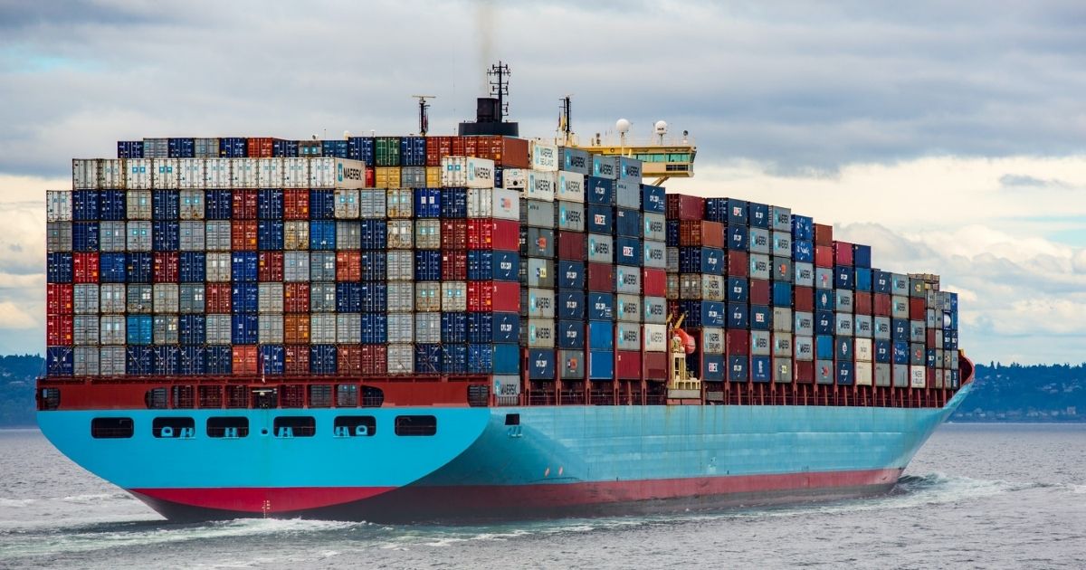 Cargo ship with stacked crates sailing in the water