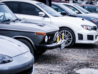 The above stock image shows a line of cars.