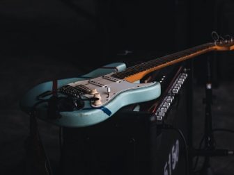Teal and brown electric guitar sitting on an amp
