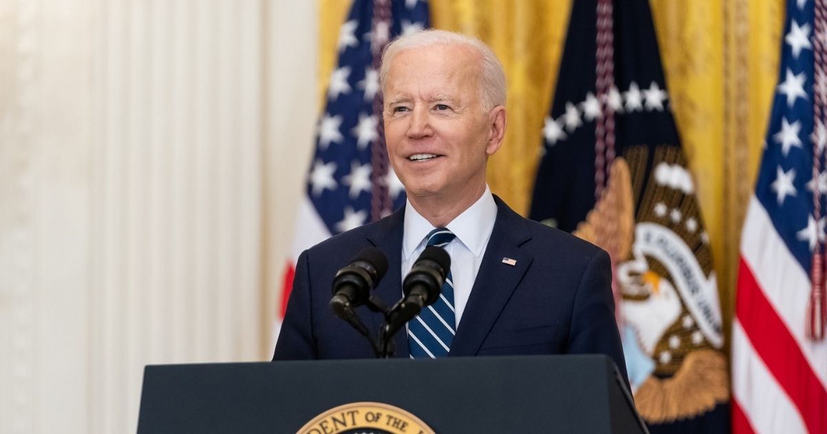 President Joe Biden speaks at the podium.