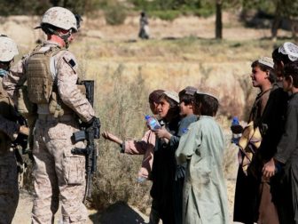 Marines with India Company, 3rd Battalion, 4th Marine Regiment, hand out water to local children during a patrol of the village of Kace Satar, Afghanistan, Nov. 11.