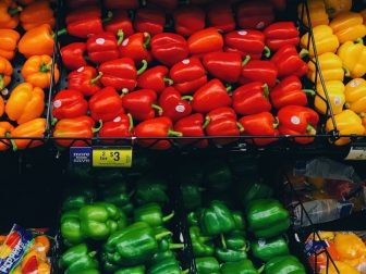 Piles of bell peppers in a grocery store