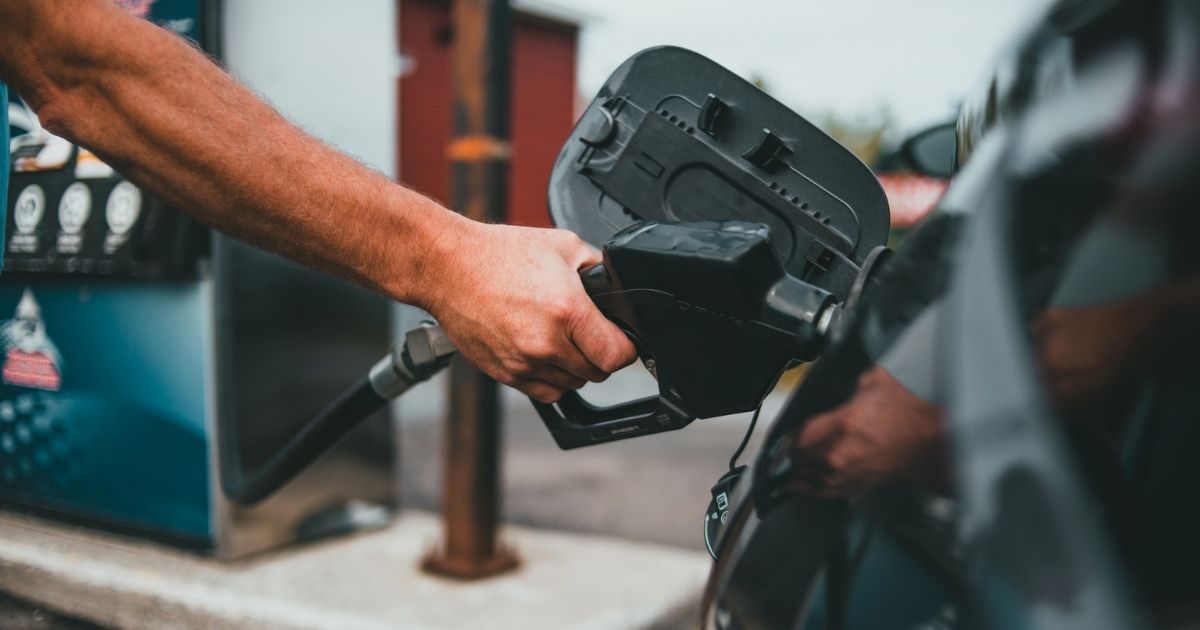 A person putting gas into a vehicle.