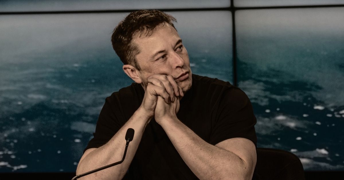 SpaceX and Tesla CEO Elon Musk listens at a meeting.