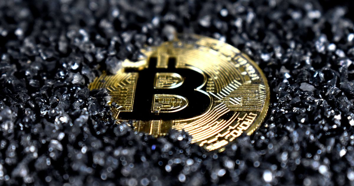 A Bitcoin covered in black crystals.