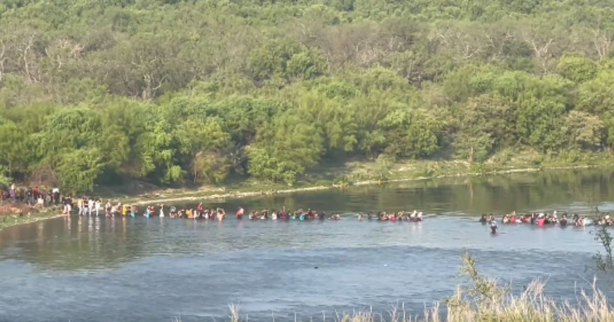 A large group of migrants cross illegally at the border into Eagle Pass, Texas, in June.