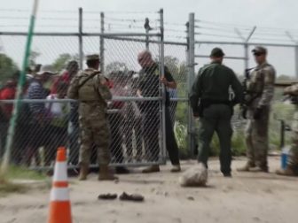 Border Patrol agents are opening a gate in this photo.