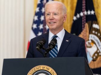 President Joe Biden speaks behind a podium.