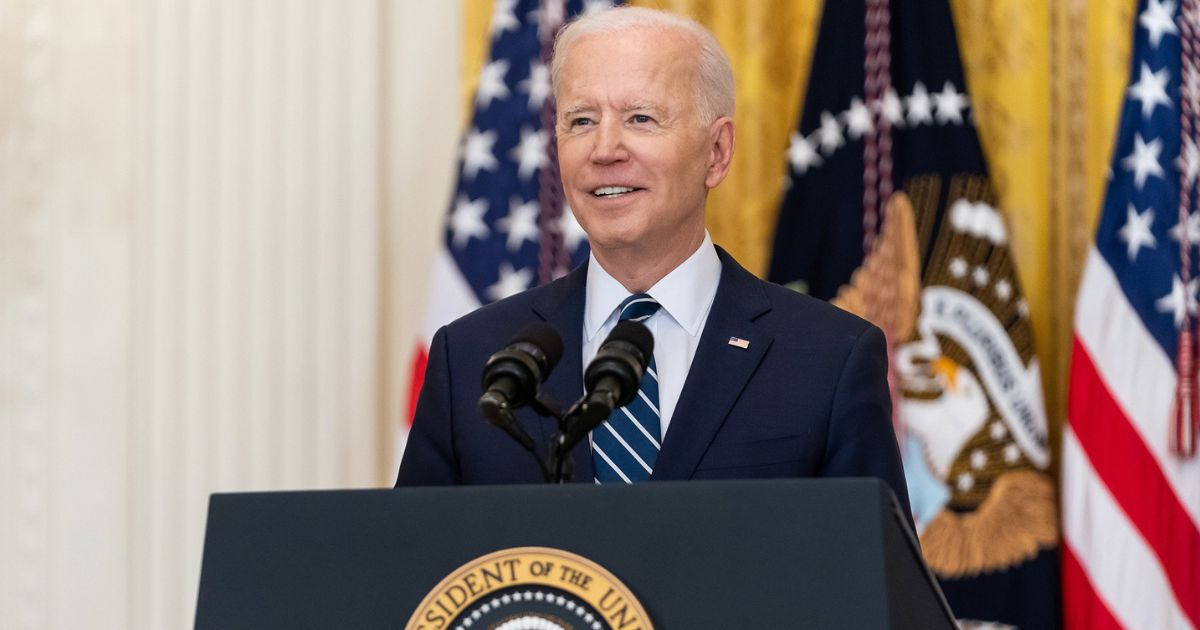 President Joe Biden speaks behind a podium.