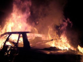 A burning car at night is seen in this photo.