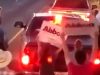 Protesters are seen chasing away a vehicle in this Twitter screen shot.