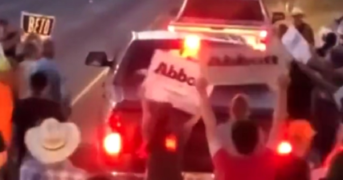 Protesters are seen chasing away a vehicle in this Twitter screen shot.