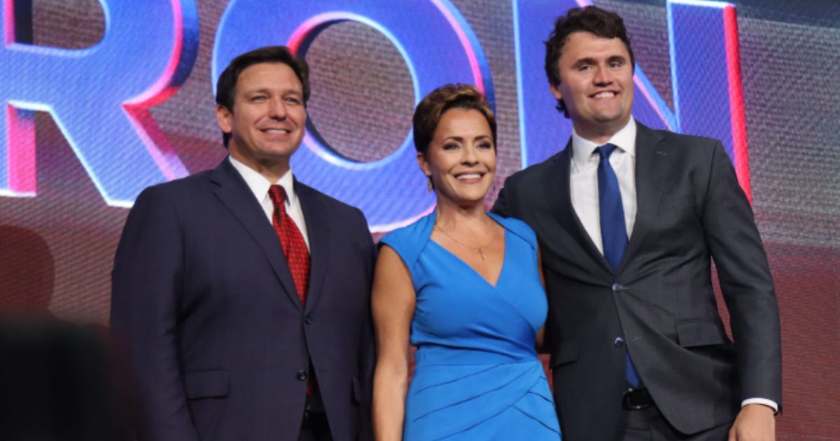 Florida Gov. Ron DeSantis, left, is seen with Republican Kari Lake, middle, at the Unite and Win Rally in Phoenix. The event was hosted by Turning Point, founded by Charlie Kirk, right.