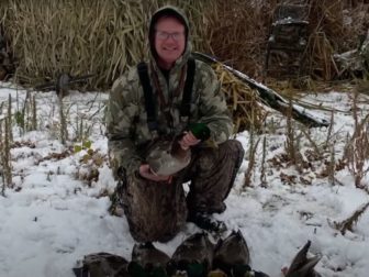 A hunter holds a duck in this photo.