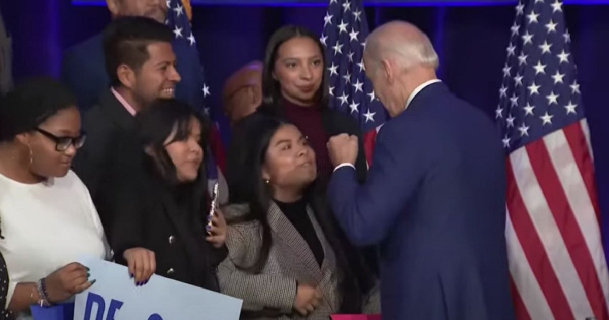 President Joe Biden puts his fists to a young woman's face after a speech Tuesday in Washington.