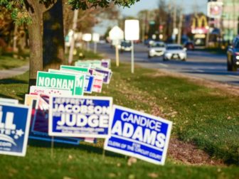 Motorists pass campaign signs just-outside the "No Electioneering" boundary in DuPage County, IL, outside Chicago.