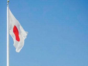 Hiroshima, Japanese flag over the cherry blossoms.