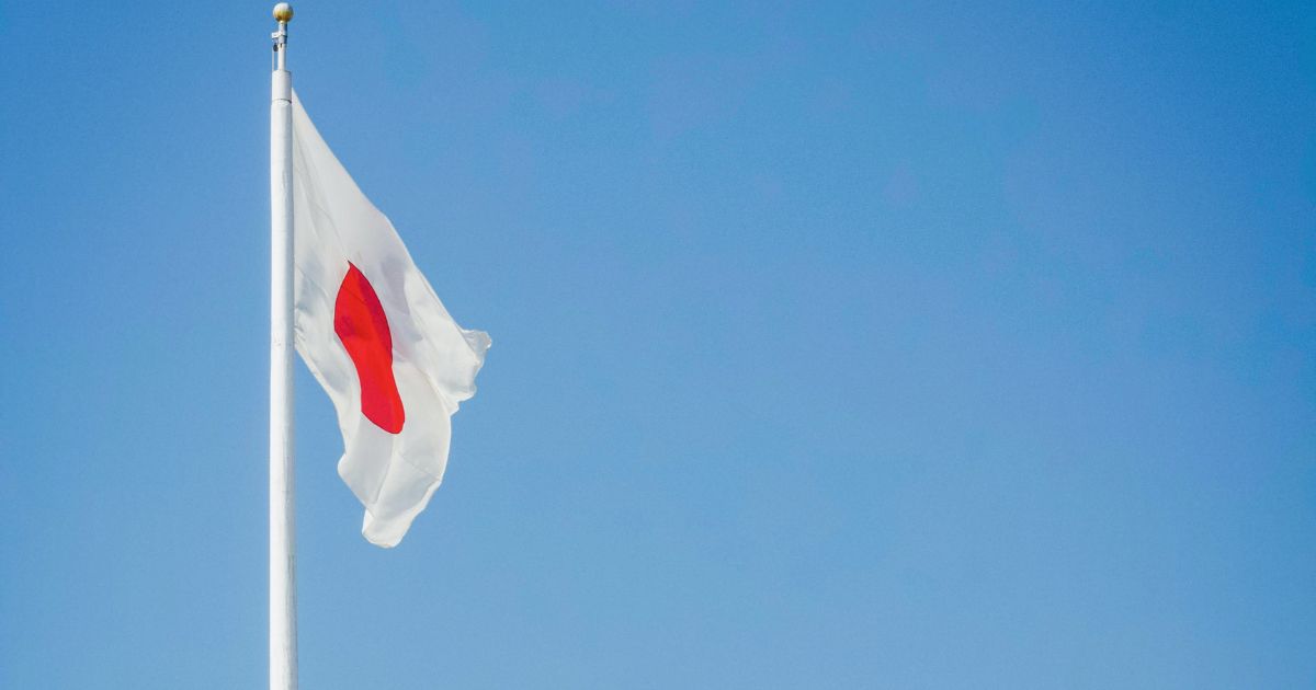 Hiroshima, Japanese flag over the cherry blossoms.