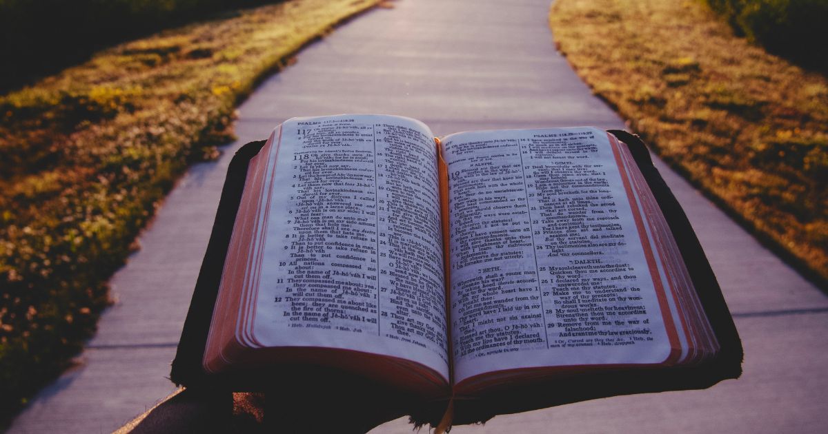 A person holding an open Bible.