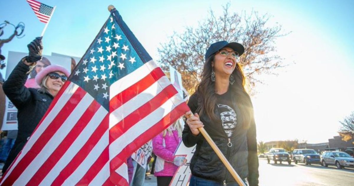 Republican Rep. Lauren Boebert holds a U.S. flag.