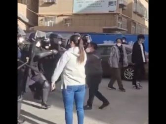 A lone woman stood against a line of Chinese riot police.