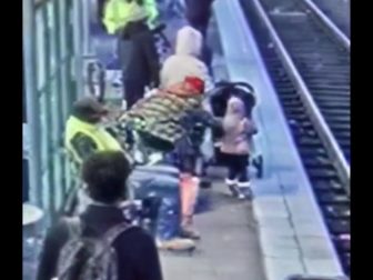 This video screen shot shows a person shoving a child onto train tracks in Portland.