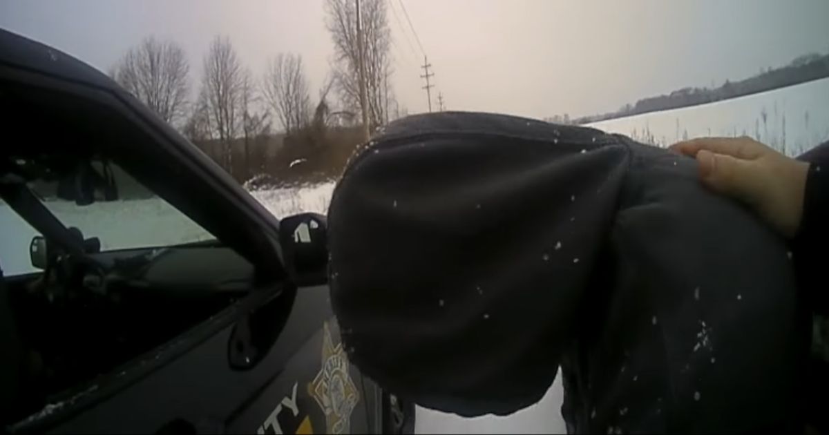 Deputy Jake Thorne of the Macomb County Sheriff's Office in Michigan helps a despondent man on the side of the road.