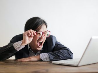 A person yelling watching news on a laptop.