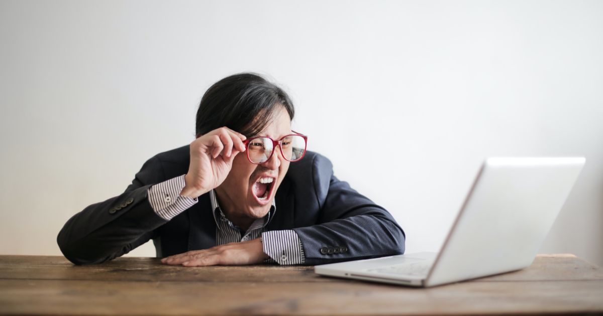 A person yelling watching news on a laptop.