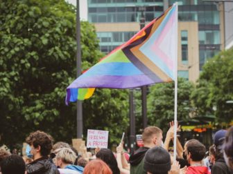 Protesters gathered in a street with a trans flag.