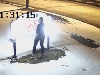 A woman identified as Hannah Kamke, 39, paints graffiti on the sign of a pro-life pregnancy center in Amherst, New York.