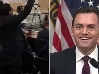 Committee Chairman Mike Gallagher, right, a Wisconsin Republican, laughed at the protester with the upside-down sign, left.