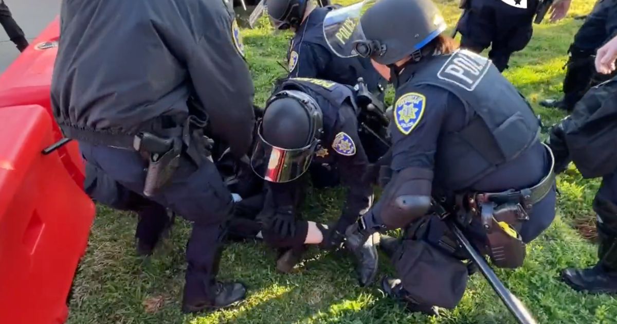 Police are seen stopping individuals that were trying to block the entrance to Charlie Kirk's speech in California.